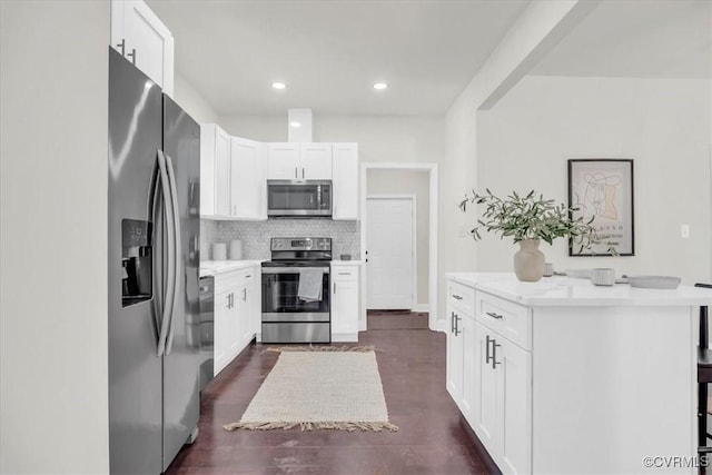 kitchen featuring appliances with stainless steel finishes, light countertops, white cabinetry, and tasteful backsplash