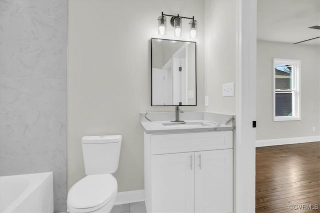 full bath featuring wood finished floors, vanity, toilet, and baseboards