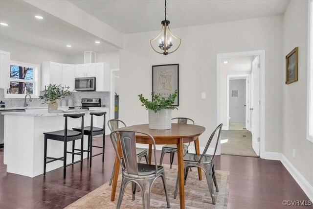 dining room with a notable chandelier, recessed lighting, dark wood-style floors, and baseboards