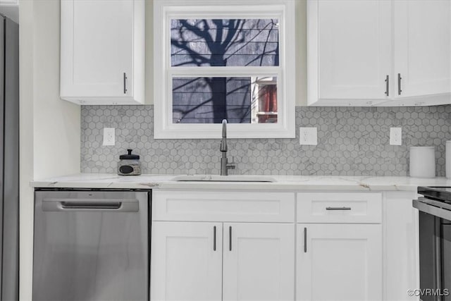 kitchen featuring appliances with stainless steel finishes, a sink, light stone counters, and white cabinets