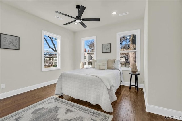 bedroom with dark wood-style flooring, visible vents, and baseboards