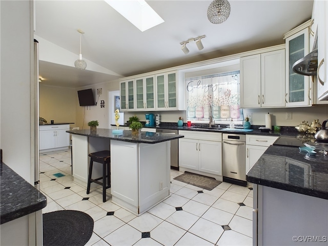 kitchen featuring a breakfast bar area, a kitchen island, white cabinets, lofted ceiling with skylight, and glass insert cabinets