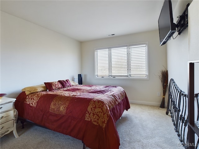 bedroom with light carpet, visible vents, and baseboards