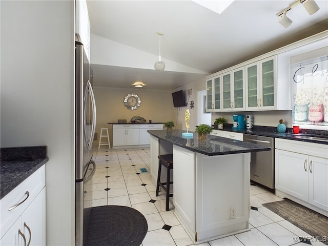 kitchen with glass insert cabinets, a kitchen breakfast bar, a center island, stainless steel appliances, and white cabinetry