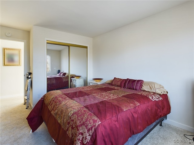 bedroom featuring baseboards, a closet, and light colored carpet