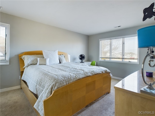 bedroom with light carpet, visible vents, and baseboards