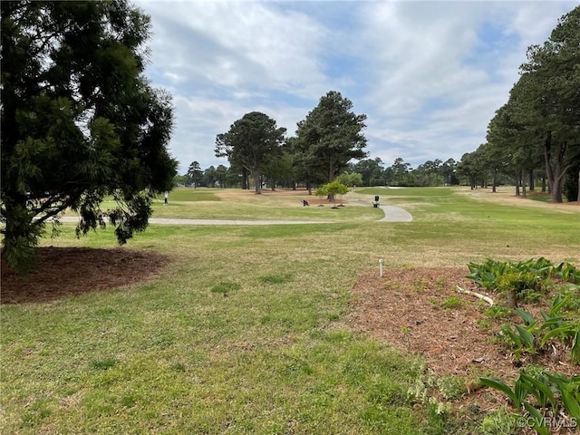 view of home's community with golf course view and a lawn