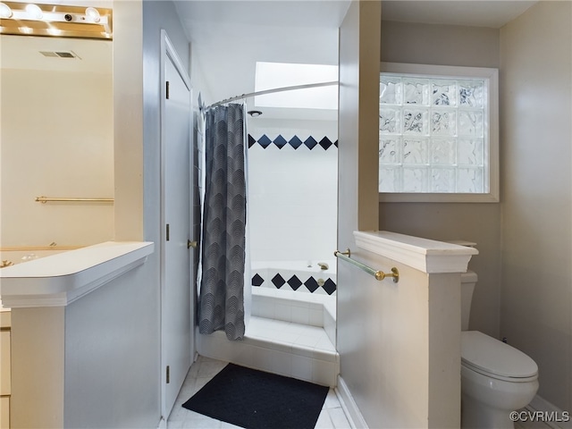 bathroom featuring toilet, a stall shower, and visible vents