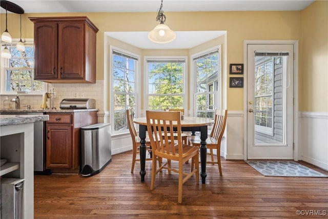 dining room featuring dark wood finished floors, plenty of natural light, and baseboards