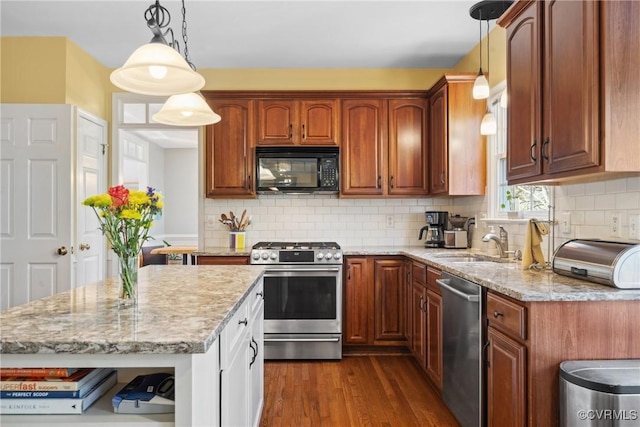 kitchen featuring a sink, backsplash, dark wood finished floors, stainless steel appliances, and light stone countertops