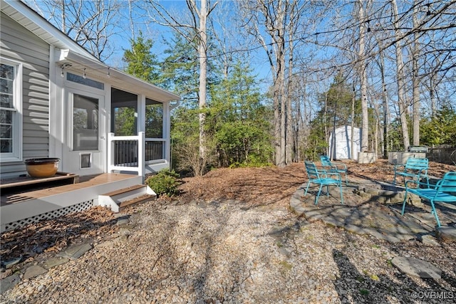 view of yard with an outbuilding, a storage shed, and a sunroom