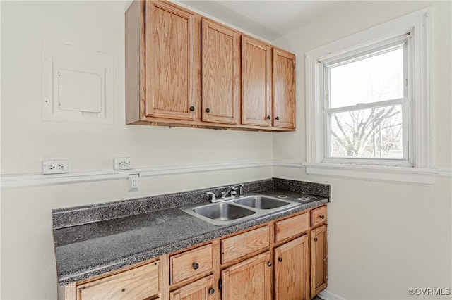 kitchen with dark countertops, a sink, and electric panel