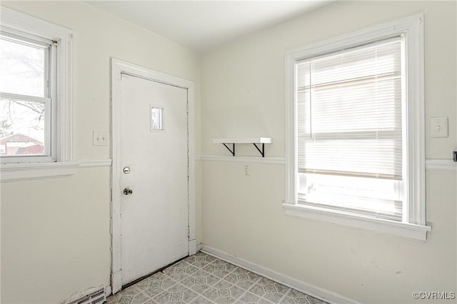 interior space featuring light floors, plenty of natural light, and baseboards