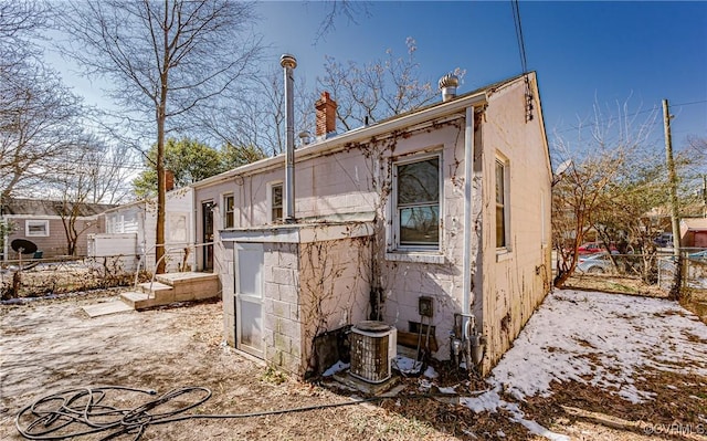 back of house featuring fence and a chimney