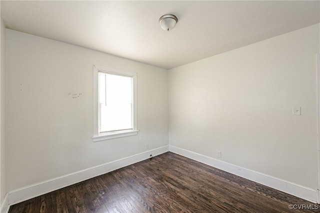 empty room with dark wood-style floors and baseboards