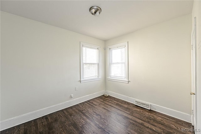 spare room with visible vents, dark wood finished floors, and baseboards