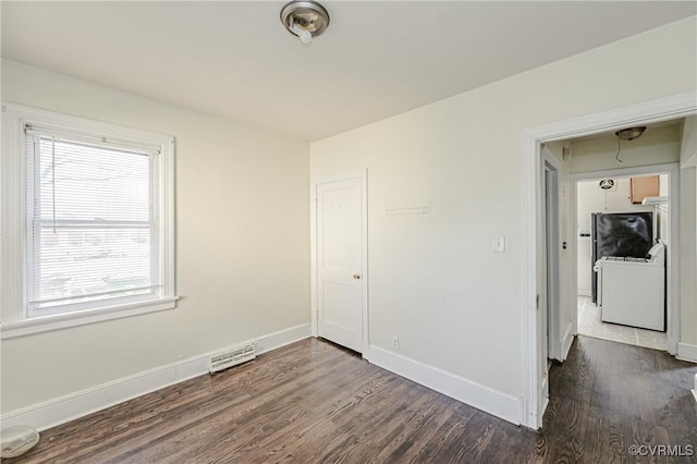 empty room featuring washer / dryer, baseboards, visible vents, and dark wood-type flooring