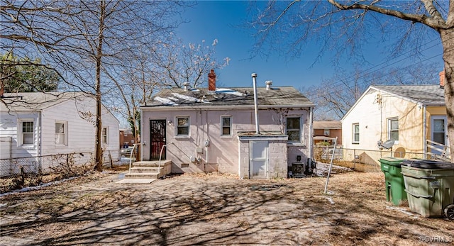 rear view of house with fence and a chimney