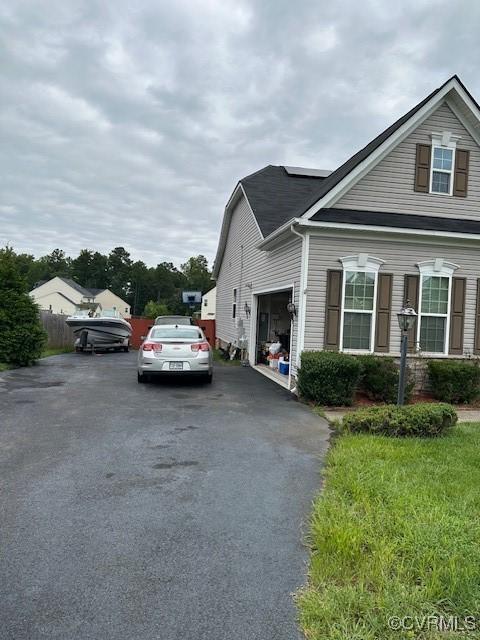 view of side of home with driveway and a garage