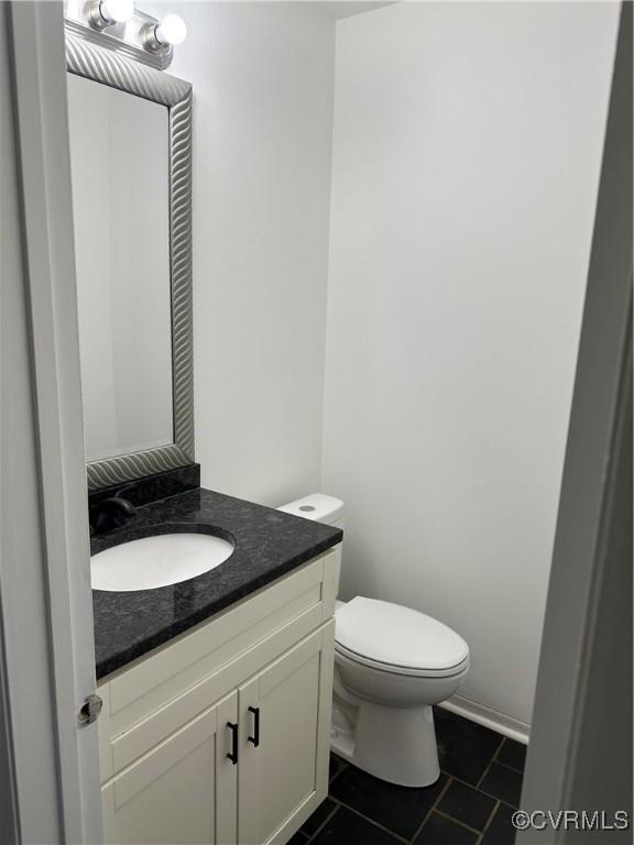 bathroom with toilet, tile patterned flooring, and vanity