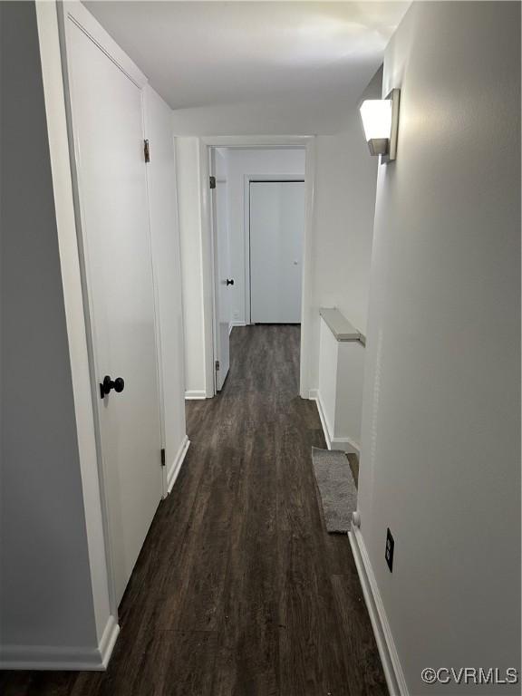 hallway with baseboards and dark wood finished floors