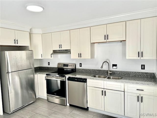 kitchen featuring under cabinet range hood, stainless steel appliances, a sink, white cabinets, and dark stone counters