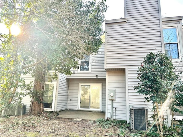 back of property with a patio area, a chimney, and central AC unit