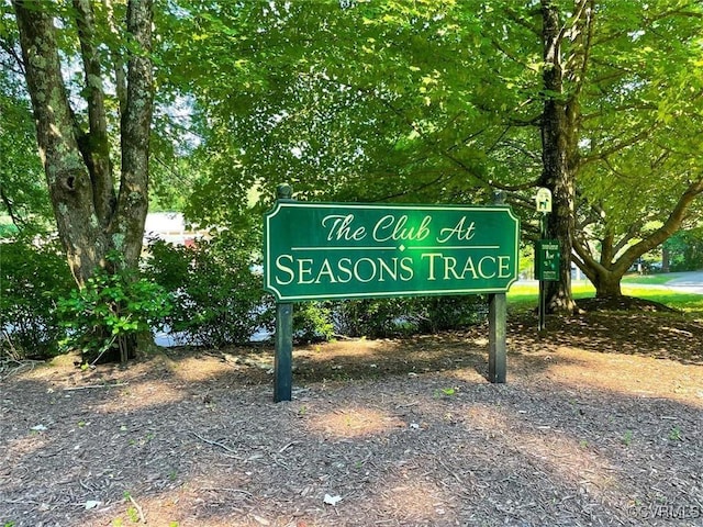 community / neighborhood sign with a carport and gravel driveway