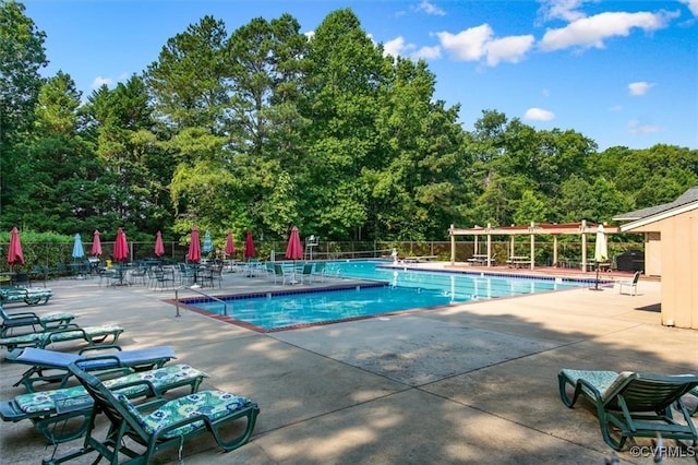 community pool featuring a pergola, fence, and a patio