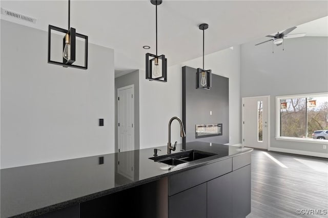 kitchen with visible vents, pendant lighting, a sink, and open floor plan