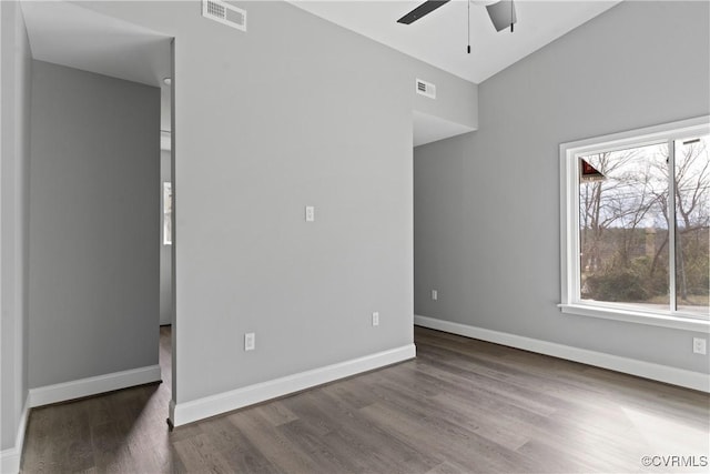 interior space with dark wood-style floors, visible vents, and baseboards