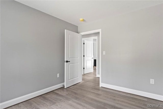 unfurnished room featuring light wood finished floors and baseboards