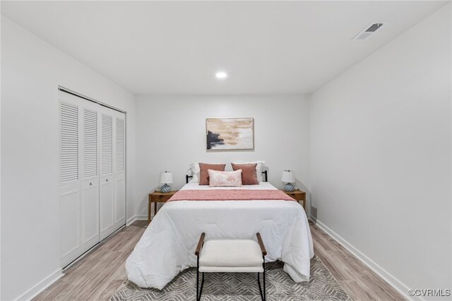 bedroom with visible vents, baseboards, light wood-type flooring, a closet, and recessed lighting