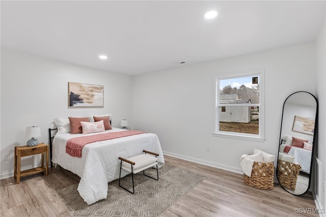 bedroom featuring baseboards, light wood finished floors, and recessed lighting