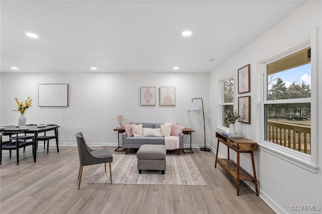 living area with light wood-style flooring, baseboards, and recessed lighting