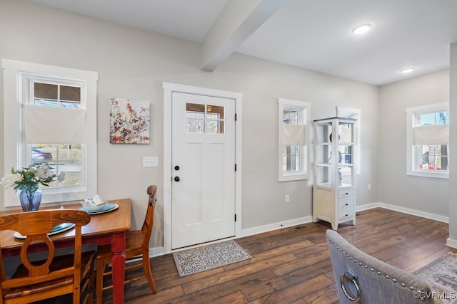 foyer with dark wood-style floors, baseboards, and beamed ceiling