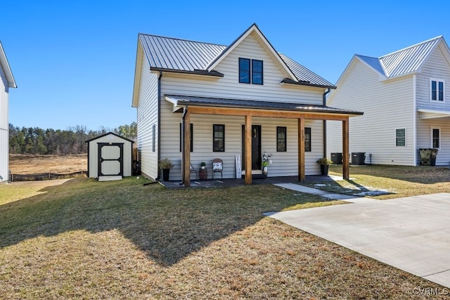 view of front of home featuring an outbuilding, metal roof, a porch, a storage shed, and a front yard