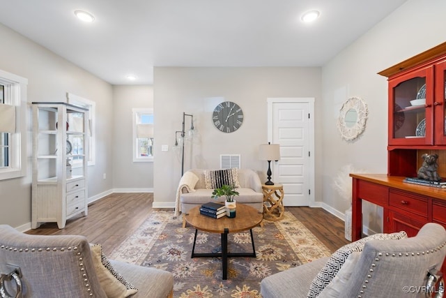 living room featuring dark wood-style flooring, recessed lighting, visible vents, and baseboards