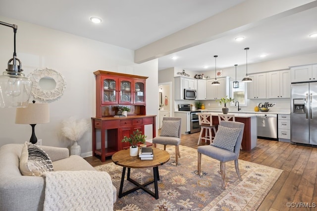 living area featuring recessed lighting, baseboards, dark wood-style flooring, and beamed ceiling