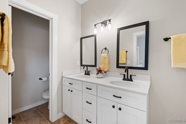 full bathroom with tile patterned flooring, a sink, toilet, and double vanity