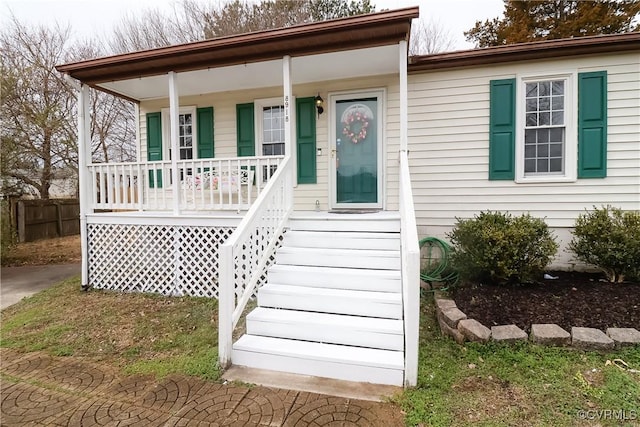 view of front of home featuring a porch and fence