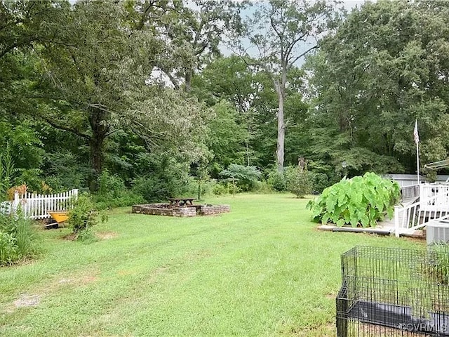 view of yard with an outdoor fire pit and fence