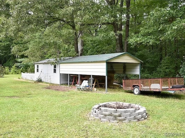 view of outbuilding featuring a carport and a fire pit