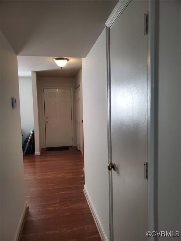 corridor with baseboards and dark wood-style flooring