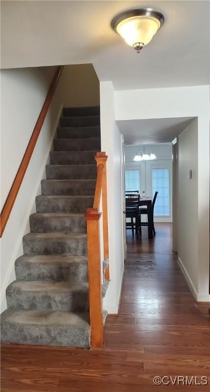 stairway featuring baseboards and wood finished floors