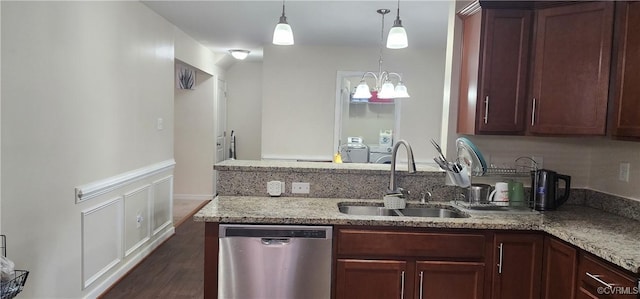 kitchen with a sink, light stone countertops, pendant lighting, and stainless steel dishwasher