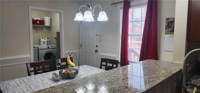 dining space featuring a chandelier and independent washer and dryer