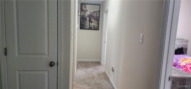 corridor featuring light carpet and baseboards