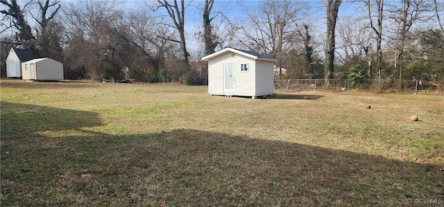 view of yard with an outbuilding, a shed, and fence