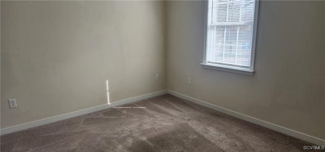 unfurnished room with carpet floors and baseboards